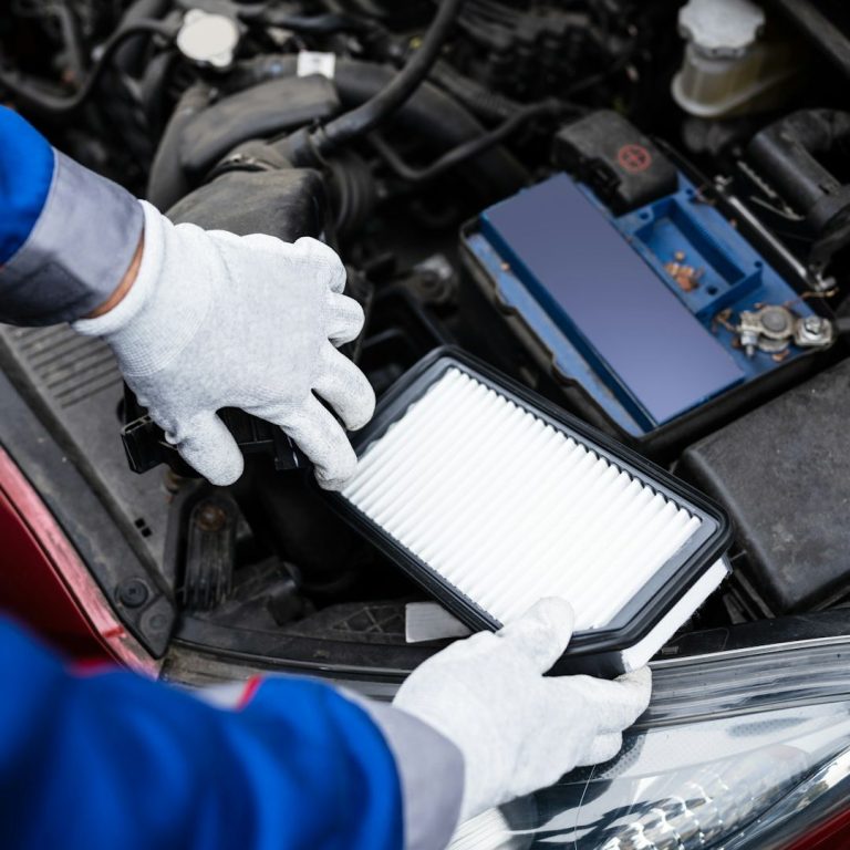 Mechaniker tauscht den Luftfilter in einem Auto aus.