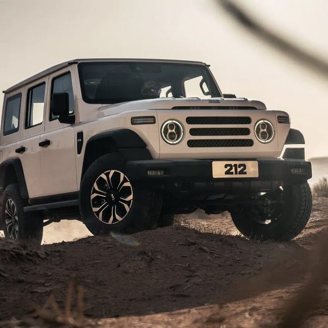 Grüner Geländewagen "Foton 4 Ultra" mit schwarzen Felgen, im Wald auf Gras platziert.